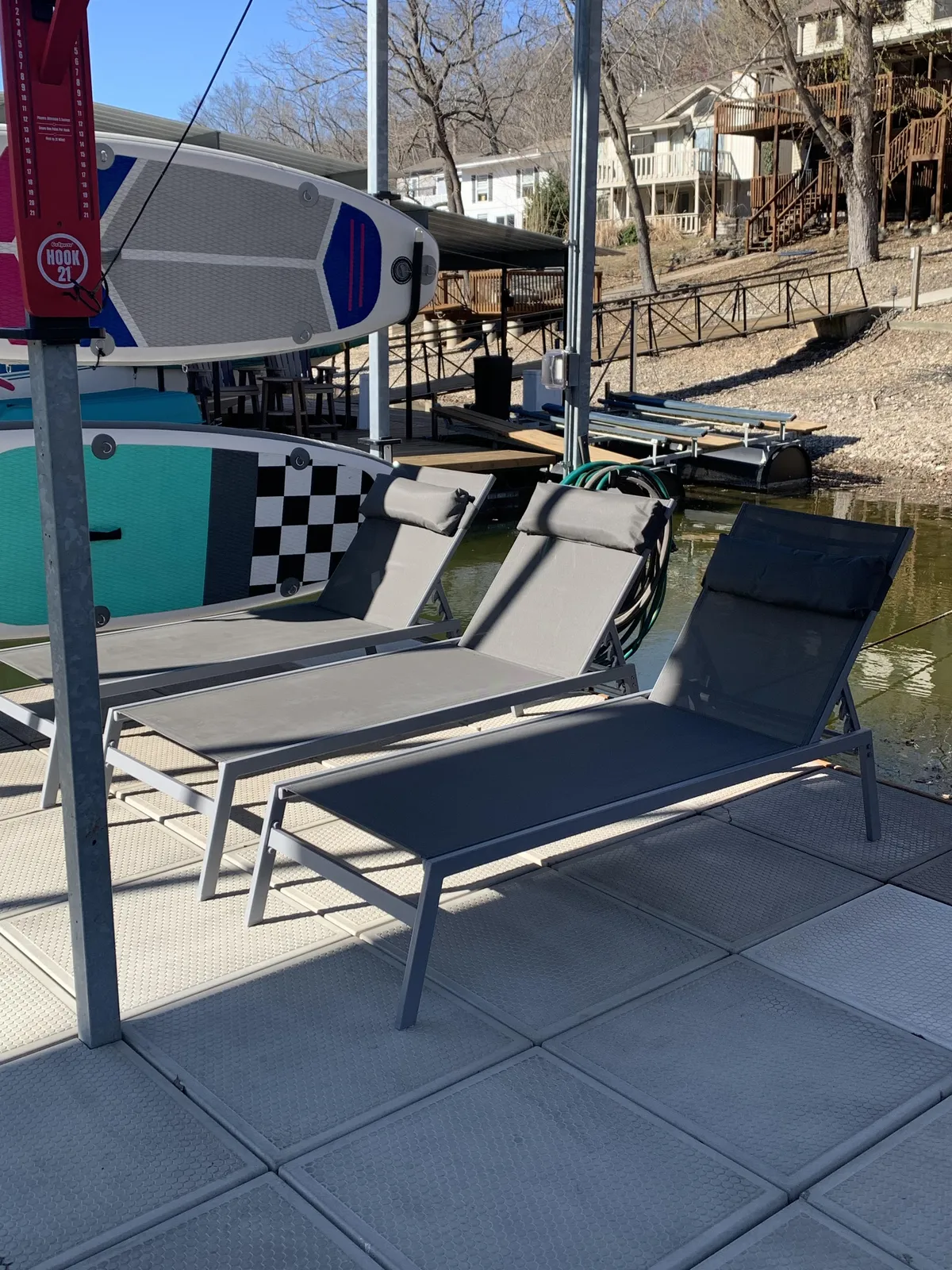 This image showcases a private dock furnished with lounge chairs and paddleboards, set against a serene lake backdrop. The dock is equipped for both relaxation and water activities, capturing the spirit of lakeside leisure and adventure described in the section.