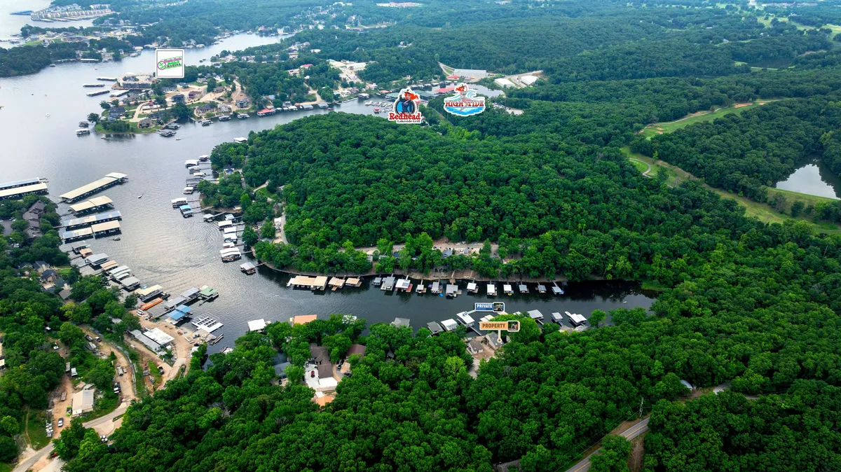 A scenic view of lush greenery and calm water, with boathouses, marinas, and hints of distant commercial establishments. The image captures both the natural beauty and proximity to local attractions, emphasizing the blend of leisure and exploration.