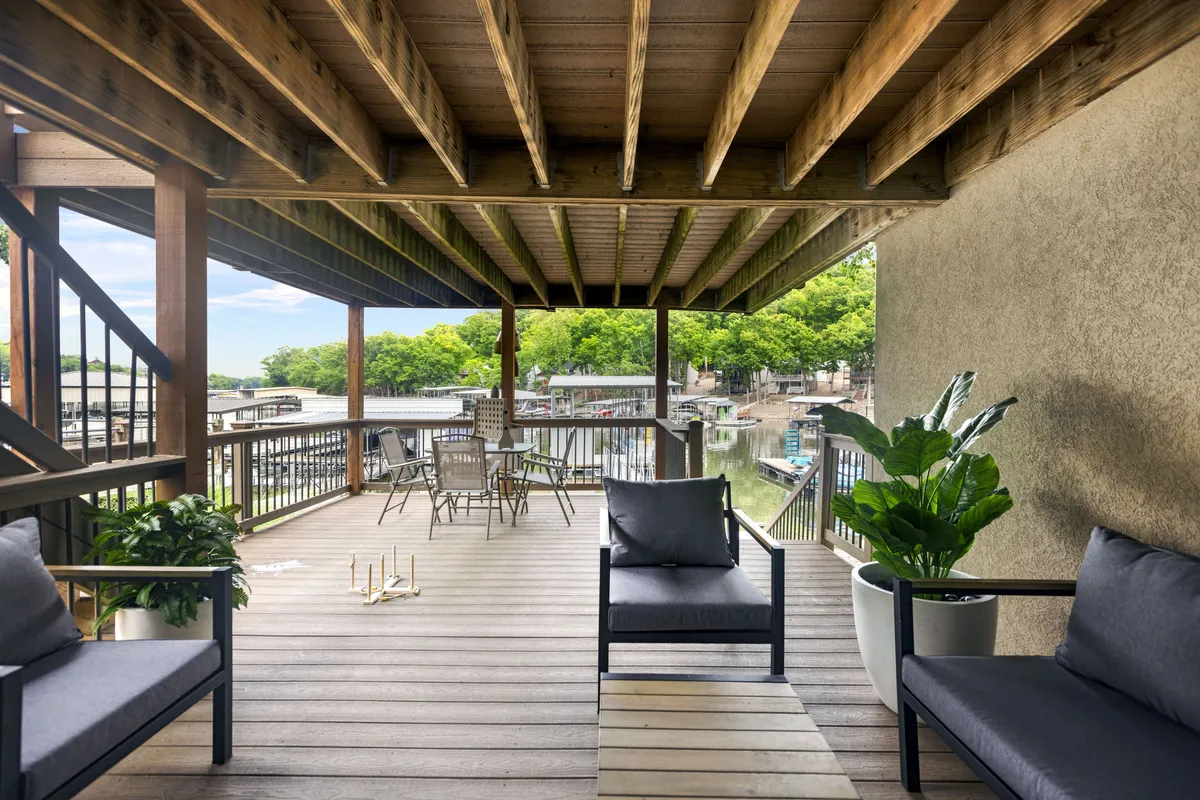 An inviting deck with comfortable seating, a dining table, and a stunning waterfront view surrounded by greenery. The area is ideal for family meals, s'mores, and sunset gatherings after a day full of lakeside adventures.